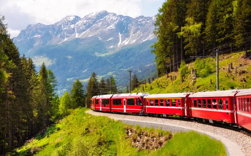 Red train moving in beautiful mountain landscape in Switzerland