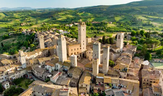 Aerial view of famous medieval San Gimignano hill town with its skyline of medieval towers, including the stone Torre Grossa. UNESCO World Heritage Site. Province of Siena, Tuscany, Italy.