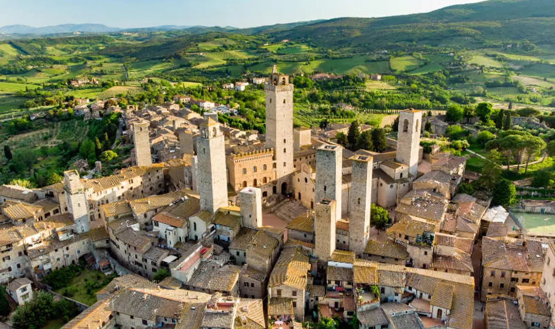 Aerial view of famous medieval San Gimignano hill town with its skyline of medieval towers, including the stone Torre Grossa. UNESCO World Heritage Site. Province of Siena, Tuscany, Italy.