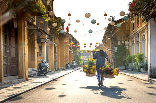 Woman carrying flowers in Hoi An in Vietnam in spring